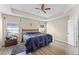 Spacious bedroom with a ceiling fan, a tray ceiling, and wood look flooring at 17843 Golden Leaf Ln, Orlando, FL 32820