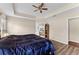 Bedroom with a bed, ceiling fan, tray ceilings and entry to the en suite bathroom at 17843 Golden Leaf Ln, Orlando, FL 32820