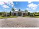 Community clubhouse with meticulously manicured landscaping, set on a paver driveway and blue skies at 17843 Golden Leaf Ln, Orlando, FL 32820