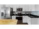 Modern kitchen featuring stainless steel appliances, white cabinets, and black countertops at 17843 Golden Leaf Ln, Orlando, FL 32820