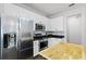 Modern kitchen featuring stainless steel appliances, white cabinetry, and a wooden island for meal preparation at 17843 Golden Leaf Ln, Orlando, FL 32820