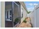View of the screened-in patio door and narrow walkway on the side of the house at 17843 Golden Leaf Ln, Orlando, FL 32820
