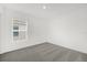 An empty bedroom features neutral carpet and a window for natural light at 8566 Caribbean Pine Way, Lakeland, FL 33809