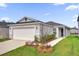 Charming single-story home features a two-car garage and a well-manicured lawn at 8566 Caribbean Pine Way, Lakeland, FL 33809