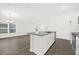 Kitchen island with granite countertop, stainless steel sink, and view to living room at 8566 Caribbean Pine Way, Lakeland, FL 33809