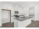 Kitchen island with granite countertop, stainless steel sink, and white cabinets at 8566 Caribbean Pine Way, Lakeland, FL 33809