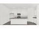 Kitchen island with granite countertop, stainless steel sink, and white cabinets at 8566 Caribbean Pine Way, Lakeland, FL 33809