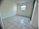 Simple bedroom with tile floors and a window offering natural light at 809 Florida Pkwy, Kissimmee, FL 34743