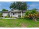 Tan house with green lawn, palm tree, and landscaping at 809 Florida Pkwy, Kissimmee, FL 34743