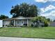 Tan house with green lawn, palm tree, and landscaping at 809 Florida Pkwy, Kissimmee, FL 34743