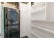 Stackable washer and dryer in well-lit laundry room with shelving at 150 E Robinson St # 1709, Orlando, FL 32801