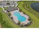 Aerial view of a community pool with a clubhouse and ample parking in a well-maintained neighborhood near a pond at 1559 Gardiner St, Haines City, FL 33844