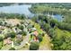 Aerial view of a home in a scenic neighborhood near a tranquil lake, surrounded by mature trees and greenery at 11602 Graces Way, Clermont, FL 34711