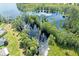 Panoramic aerial view of a lake with a wooden dock and surrounding lush greenery at 11602 Graces Way, Clermont, FL 34711