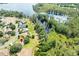 Aerial view of a charming home with access to a lake, surrounded by mature trees and serene natural beauty at 11602 Graces Way, Clermont, FL 34711