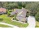 Aerial view of a well-maintained home showcasing its landscaping, driveway, and surrounding greenery at 11602 Graces Way, Clermont, FL 34711