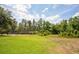 Expansive green backyard featuring lush landscaping and mature trees, offering privacy and a serene outdoor space at 11602 Graces Way, Clermont, FL 34711