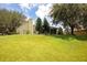 Beautiful backyard with lush lawn and mature trees features a screened-in porch for outdoor enjoyment at 11602 Graces Way, Clermont, FL 34711