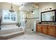 Elegant bathroom with a large glass shower, garden tub, vanity, and decorative lighting at 11602 Graces Way, Clermont, FL 34711