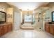 Luxurious bathroom with a corner glass shower, garden tub, double vanity, and neutral tile at 11602 Graces Way, Clermont, FL 34711