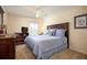 Comfortable bedroom with a Queen-size bed, dresser, neutral paint and carpet at 11602 Graces Way, Clermont, FL 34711