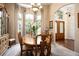 Formal dining room with large windows, chandelier lighting, and elegant wood furnishings at 11602 Graces Way, Clermont, FL 34711
