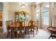 Formal dining room featuring a large table, china cabinet, and elegant chandelier lighting at 11602 Graces Way, Clermont, FL 34711