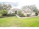 Charming home with a well-manicured lawn, lush landscaping and a brick walkway leading to the entrance at 11602 Graces Way, Clermont, FL 34711