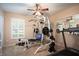 Bright home gym features a ceiling fan, weight rack, treadmill, and natural light from a window at 11602 Graces Way, Clermont, FL 34711