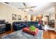 Open-concept living room with hardwood floors, ceiling fan, and seamless flow into kitchen at 11602 Graces Way, Clermont, FL 34711