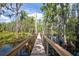 Charming wooden bridge surrounded by lush trees offers a tranquil walkway over the water at 11602 Graces Way, Clermont, FL 34711