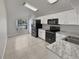 Modern kitchen featuring black appliances and marble countertops at 340 Troon Cir, Davenport, FL 33897