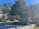 Landscaped entrance to the community with trees and a gate at 6100 Stevenson Dr # 207, Orlando, FL 32835