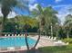 Community pool with lounge chairs and palm trees at 6100 Stevenson Dr # 207, Orlando, FL 32835