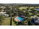 Aerial view of the community pool and jacuzzi surrounded by trees and landscaping at 2855 Gopherwood Way, Clermont, FL 34711