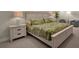 Relaxing bedroom featuring a king-size bed with tropical-themed bedding and stylish white nightstands with elegant lamps at 880 Driving Range Ct, Reunion, FL 34747