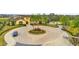 Beautiful clubhouse entrance with manicured landscaping and a circular driveway with tropical palm trees at 880 Driving Range Ct, Reunion, FL 34747