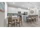 Modern kitchen with white cabinets, gray island, and stainless steel appliances at 880 Driving Range Ct, Reunion, FL 34747
