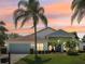 Charming single-story home featuring a well-manicured lawn and beautiful tropical landscaping at sunset at 9226 Longfellow Pl, Apopka, FL 32703
