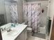 Bright bathroom with a vanity, toilet and shower-tub combination featuring stylish patterned shower curtain at 3455 Jujube Dr, Orlando, FL 32810