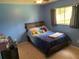 This bedroom features blue walls, natural lighting, ceiling fan, and a bed at 3455 Jujube Dr, Orlando, FL 32810