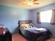 This bedroom features blue walls, natural lighting, ceiling fan, and a bed at 3455 Jujube Dr, Orlando, FL 32810