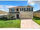 Two-story home features a two-car garage, neutral paint scheme, and manicured lawn at 5043 Sw 88Th Pl, Ocala, FL 34476