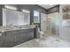 Modern bathroom with double vanity, glass shower, and marble flooring at 748 Desert Mountain Ct, Reunion, FL 34747