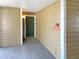Hallway leading to a front door with wood paneling, neutral walls, and clear unit identification at 4367 Thornbriar Ln # 108, Orlando, FL 32822