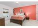 Bright bedroom with coral accent wall and a comfortable bed at 122 Blue Cypress Drive, Davenport, FL 33837