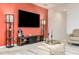 Living room with a statement coral wall, large TV and comfortable seating at 122 Blue Cypress Drive, Davenport, FL 33837