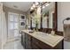 Bathroom with double vanity, dark wood cabinets, and a large mirror at 9227 Cypress Cove Dr, Orlando, FL 32819