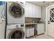 Bright laundry room, featuring washer, dryer and cabinets at 9227 Cypress Cove Dr, Orlando, FL 32819