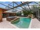 Screened pool and spa with waterfall feature and brick pavers at 9227 Cypress Cove Dr, Orlando, FL 32819